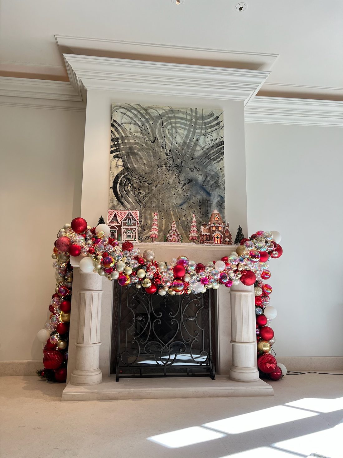 A white mantel dressed in red and white ornament garland